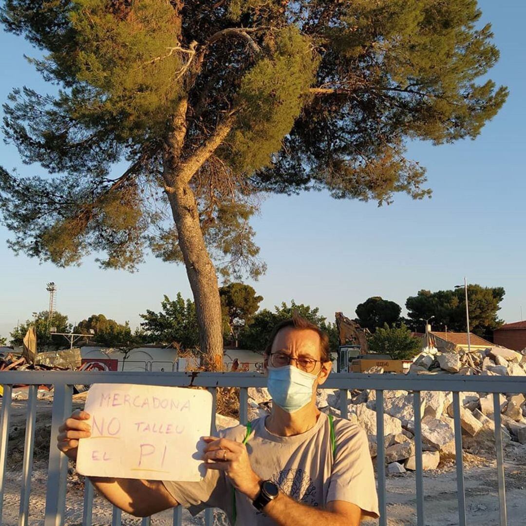 Garcia en la zona donde está ubicada el pino junto al cartelito de su campaña