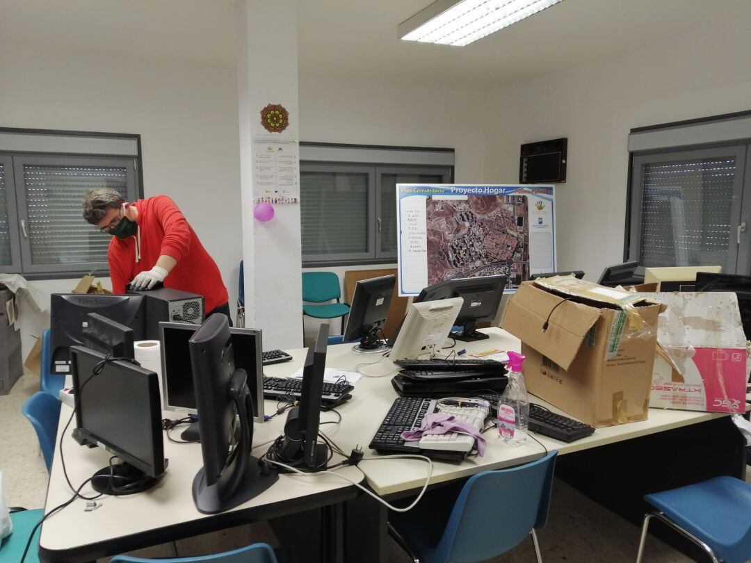 Un voluntario repara un ordenador que han donado