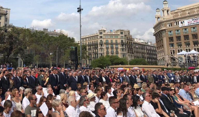 Los reyes y resto de autoridades asisten al acto central de homenaje a las víctimas de los atentados de Barcelona y Cambrils con la pancarta contra el monarca en el fondo 