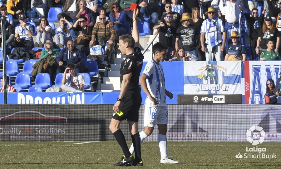 El árbitro murciano Sánchez López con una de las tres tarjetas rojas que mostró durante el Leganés - Sporting.