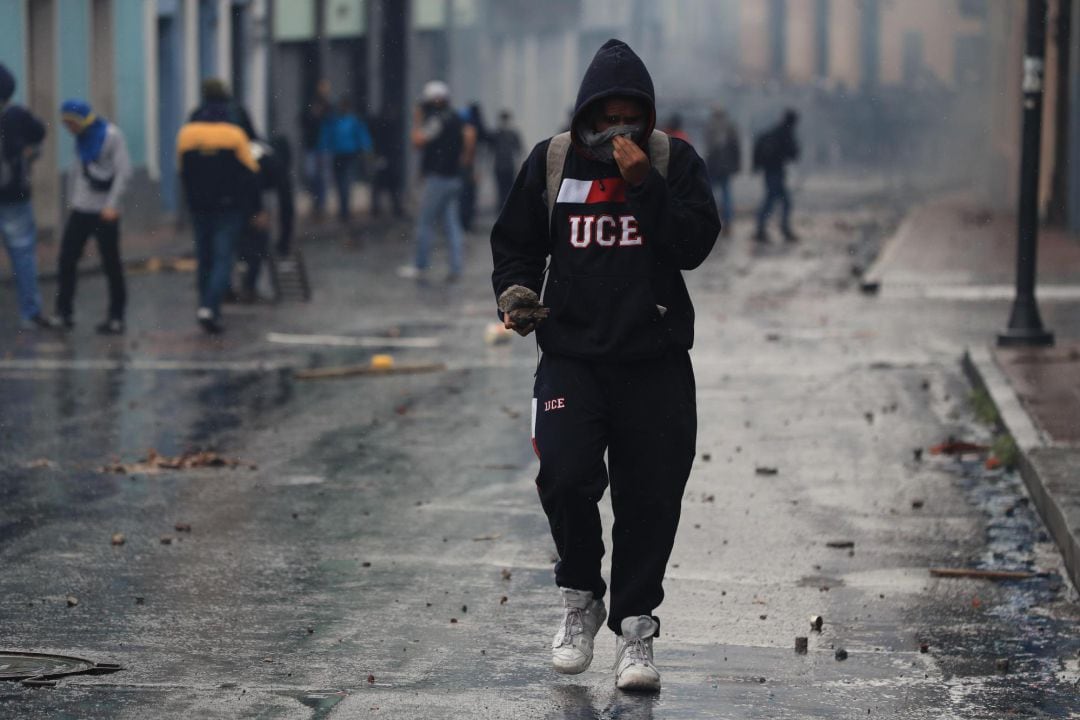 Un manifestante con su rostro cubierto sostiene algunas rocas durante una jornada de protesta contra las medidas económicas del Gobierno de Lenín Moreno en Quito 