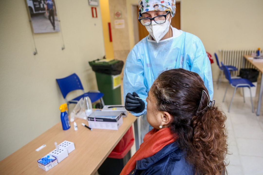 Una sanitaria realiza un test de antígenos a una mujer en un dispositivo organizado por la Comunidad de Madrid para la detección del COVID-19.