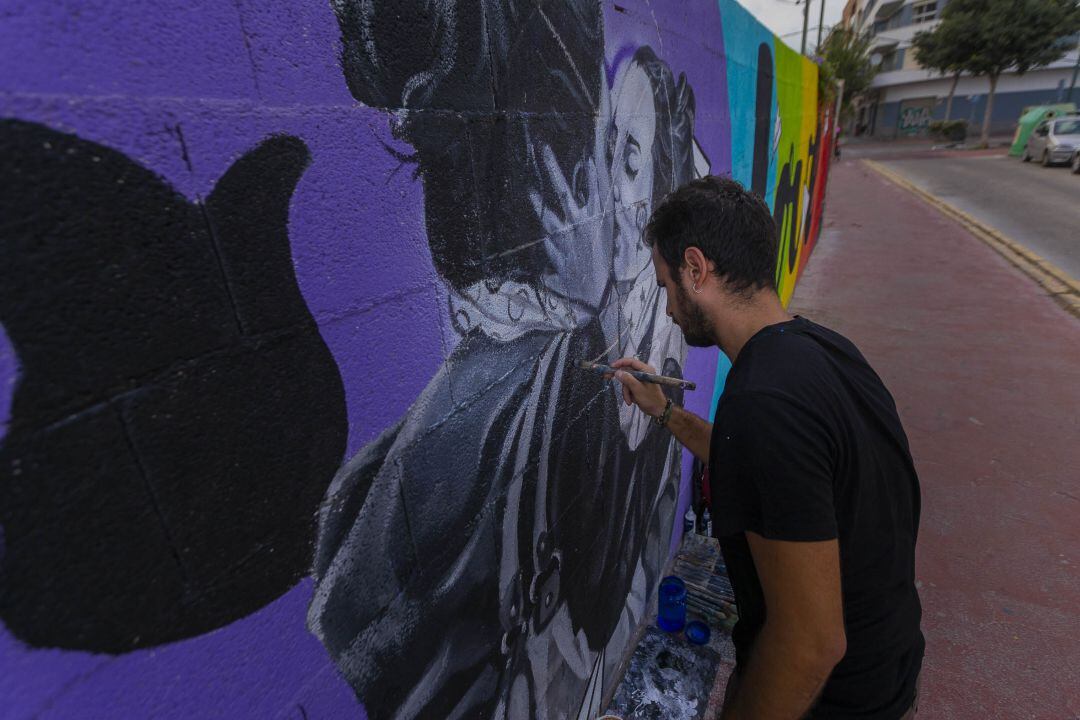 El artista, Flug, en una de las restauraciones del mural Love is Love 