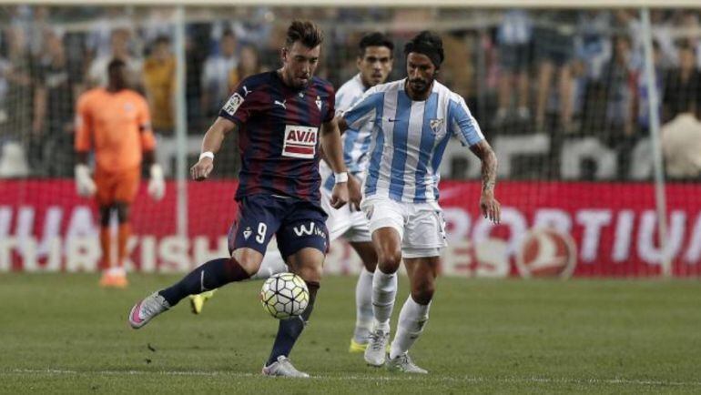 Sergi Enrich y Marcos Angeleri luchan por un balón durante el Málaga - Eibar.