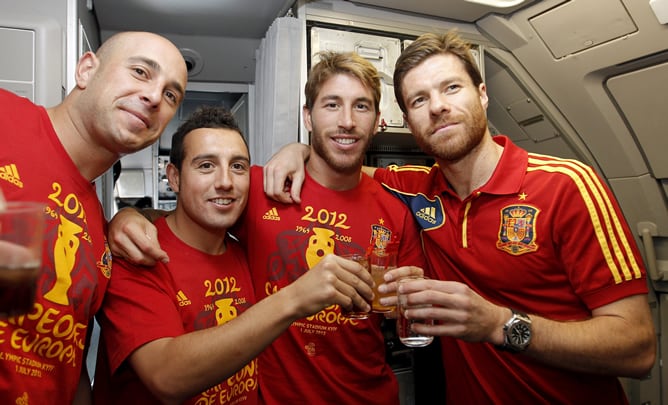 Los jugadores de la selección española de fútbol, de izquierda a derecha, Pepe Reina, Santiago Cazorla, Sergio Ramos y Xabi Alonso, posan en el avión que trasladó al equipo español desde Kiev a Madrid, tras imponerse en la final de la Eurocopa 2012 a Ital