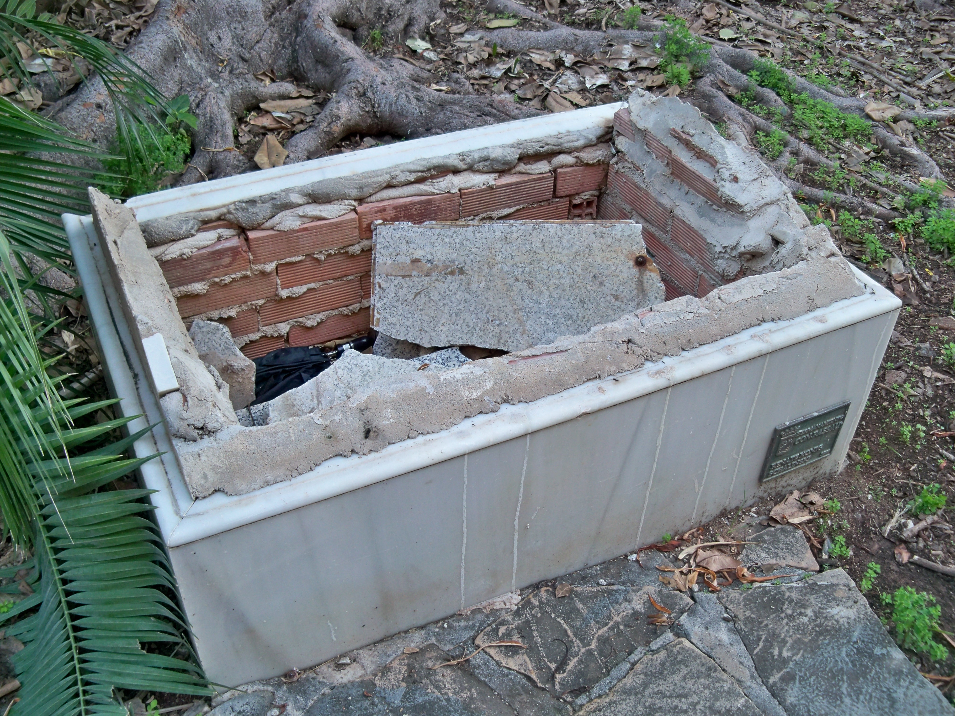 Estado de la base de granito de la estela conmemorativa del hermanamiento de las ciudades de Málaga y Passau, en los Jardines de Picasso, Málaga (marzo 2022)