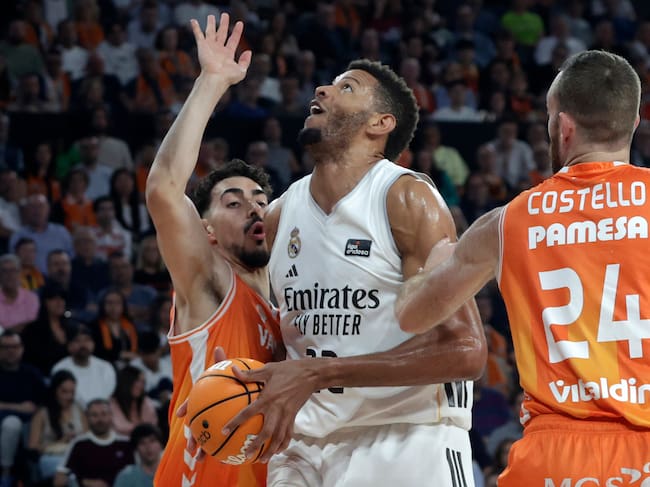 VALENCIA, 25/04/2026.- El pívot del Real Madrid Edy Tavares (c) entra a canasta ante el alero del Valencia Josep Puerto (i) durante el encuentro de la Liga Endesa entre Valencia Basket y Real Madrid, este sábado en el pabellón Roig Arena de Valencia. EFE/ Miguel Ángel Polo