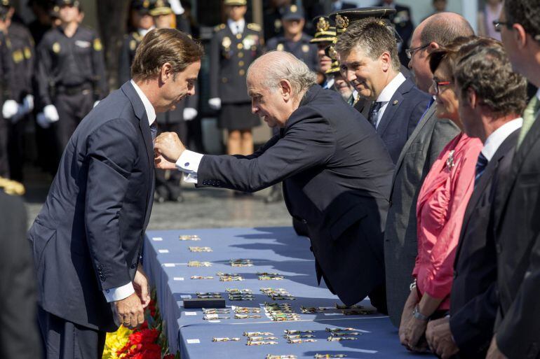 El ministro del Interior, Jorge Fernández Díaz ,c-d., impone la condecoración al mérito policial al presidente de la Audiencia Nacional, José Ramón Navarro