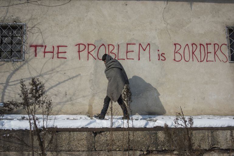 Un refugiado pasa ante una pintada en Serbia &quot;El problema es las fronteras&quot;