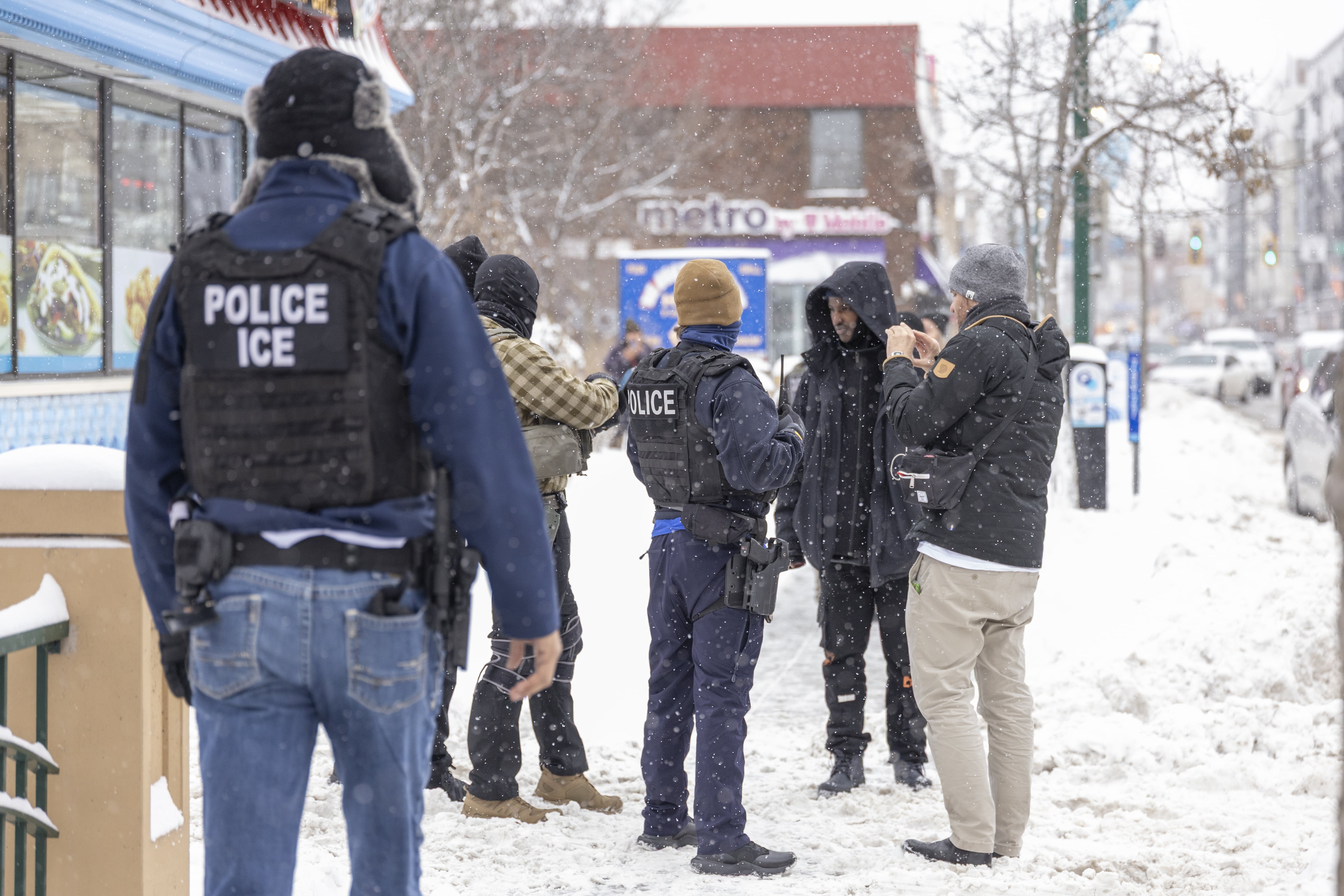 Agentes de migración con un hombre en las calles de Minnesota