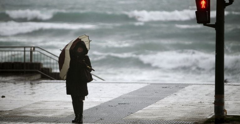 Una mujer en un paso para peatones que da acceso a la playa de Riazor.