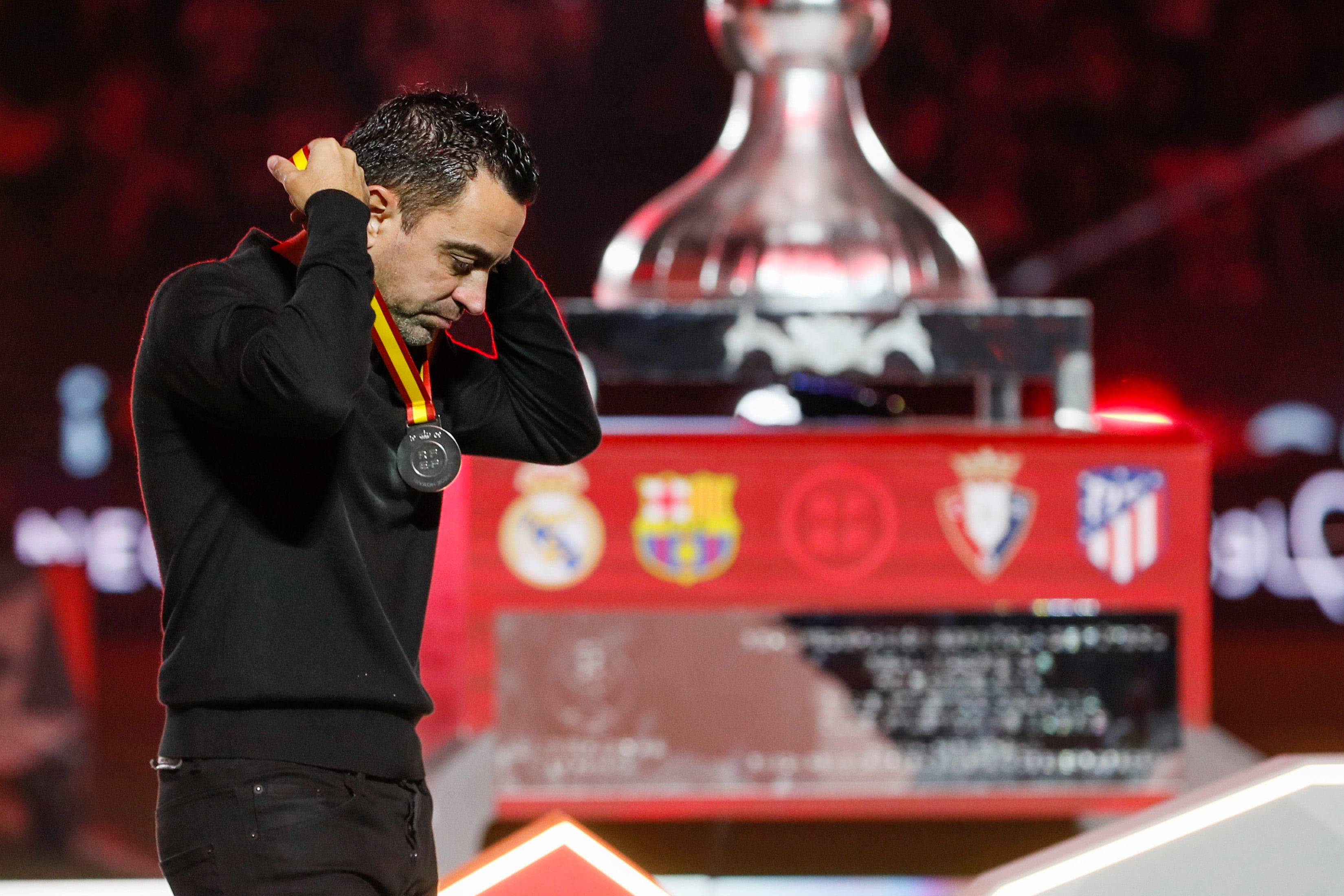 El técnico del FC Barcelona Xavi Hernández se quita la medalla de segundo clasificado.