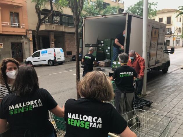 Los voluntarios de Mallorca Sense Fam descargan el camión de los Lion Club para colocar los alimentos en la sede.