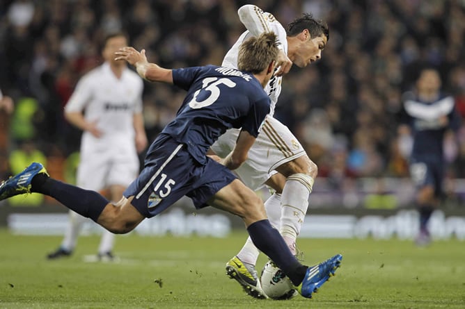 El jugador del Málaga defiende al del Real Madrid en un partido de la temporada 2011-12 disputado en el Santiago Bernabéu