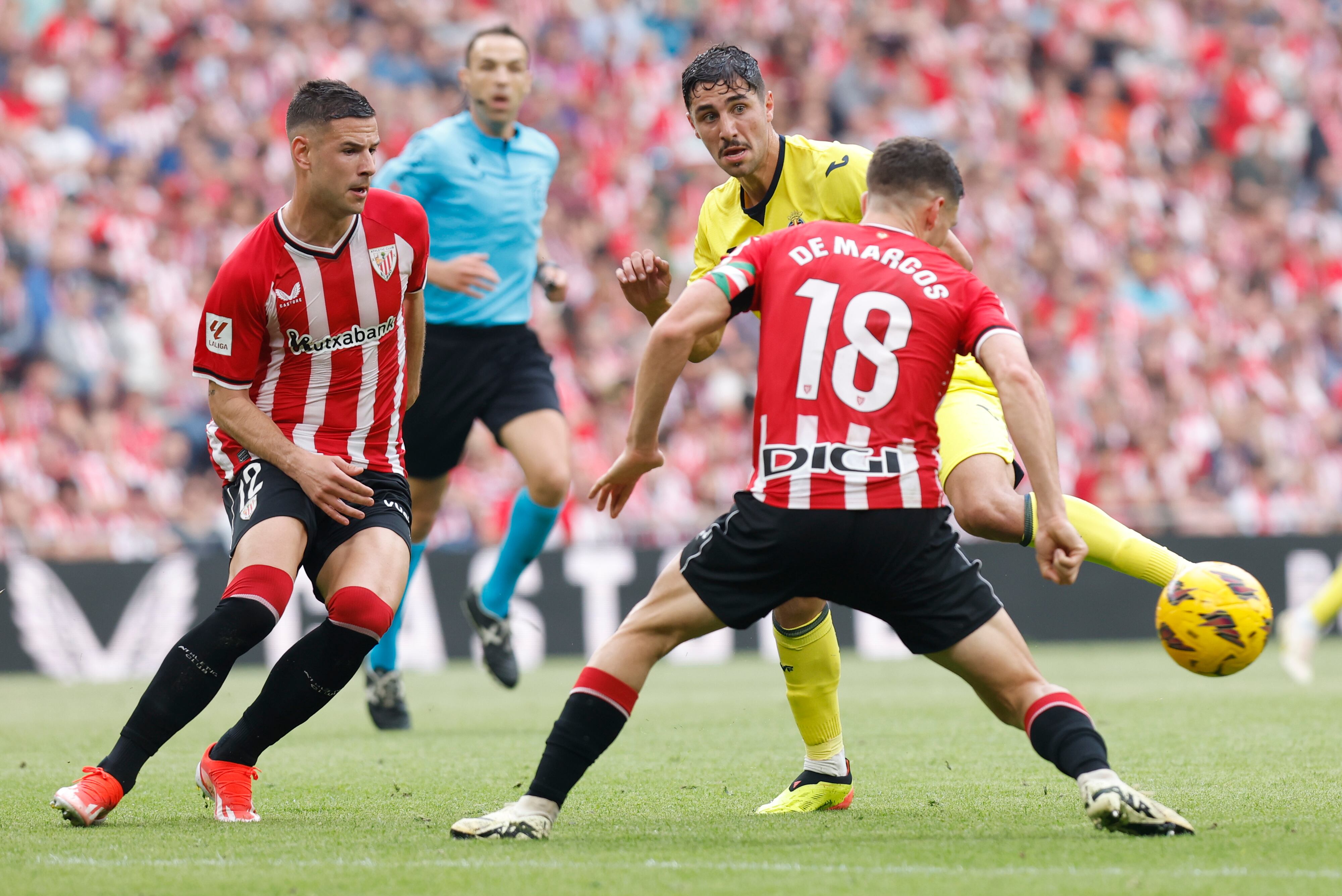 BILBAO, 14/04/2024.- El delantero Gorka Guruzeta (i) y el defensa Óscar De Marcos (d), ambos del Athletic, disputan el balón ante Santi Comesaña (c), centrocampista del Villarreal, durante el encuentro correspondiente a la jornada 31 de primera división que Athletic Club y Villarreal disputan hoy domingo en el estadio de San Mamés, en Bilbao. EFE / Miguel Toña.