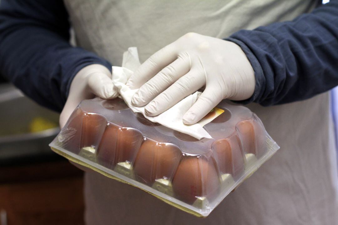 Una persona limpia una docena de huevos