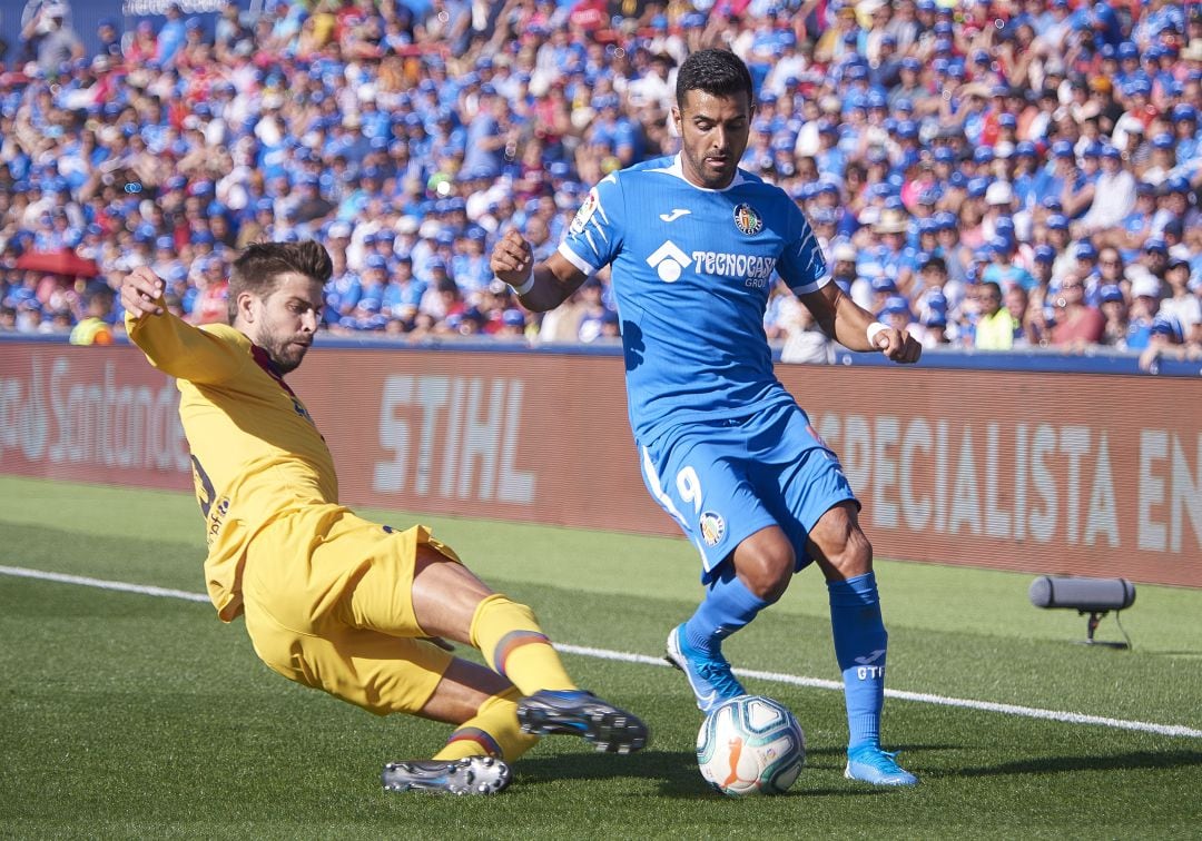 Piqué y Ángel pugnan por un balón en el Getafe - Barcelona de la pasada temporada