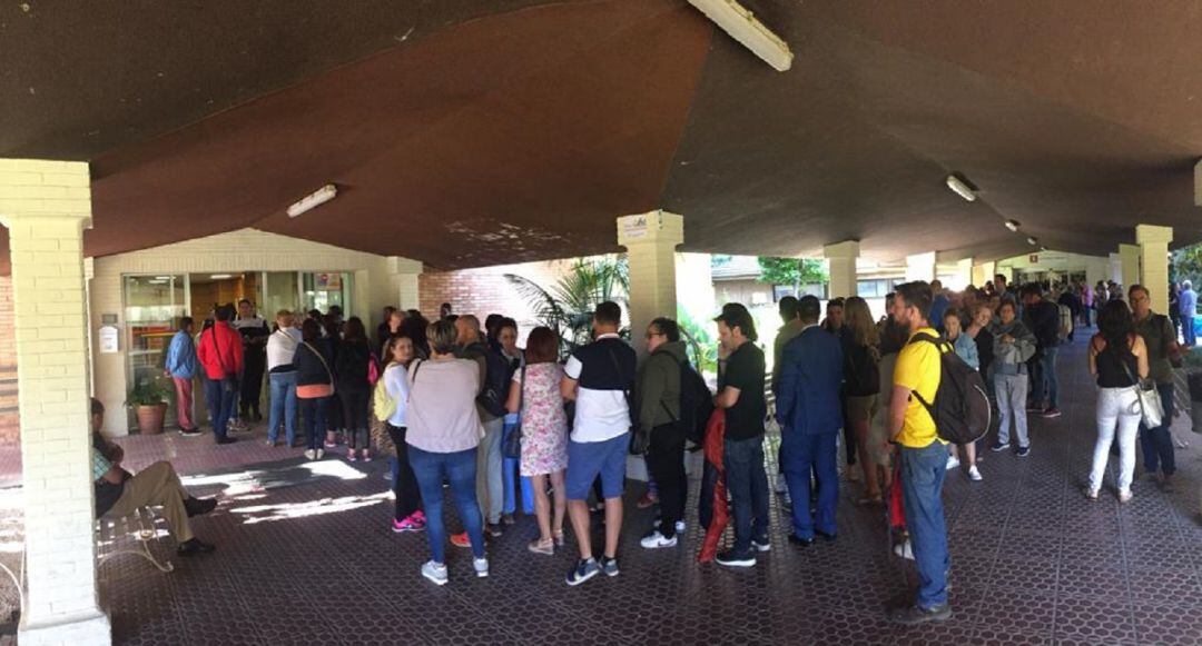 Cola de personas frente a la puerta del colegio mayor. 