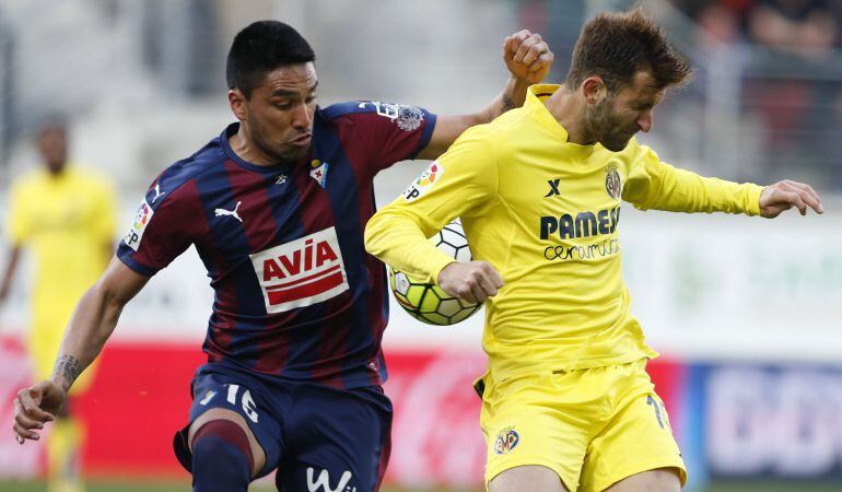 El defensa argentino del Eibar, Mauro Dos Santos (i) y el delantero brasileño del Villarreal Leo Baptistao, durante el partido de Ipurua