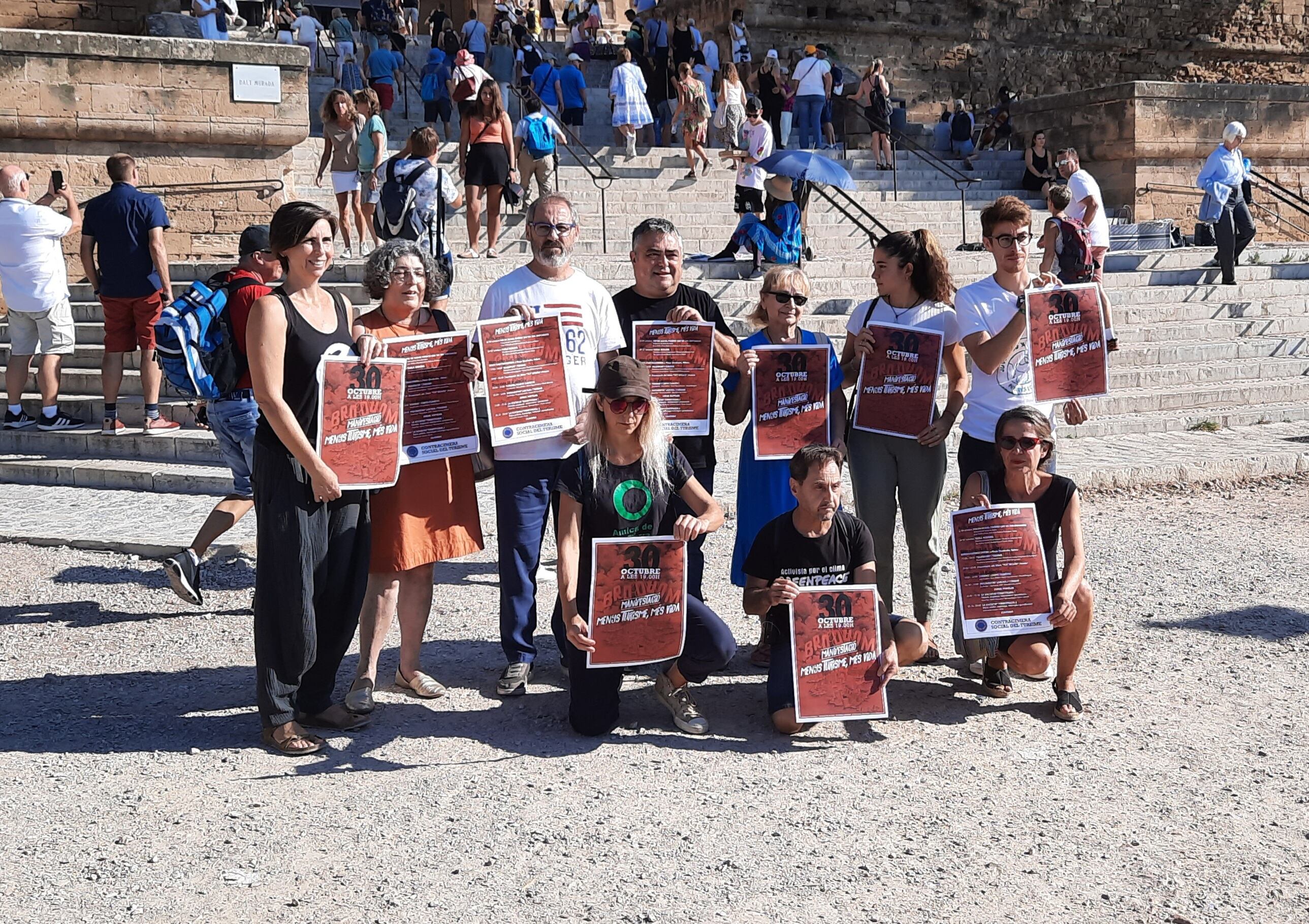 Miembros de la contracumbre contra el turismo en Palma posan a los pies de la Catedral de Palma