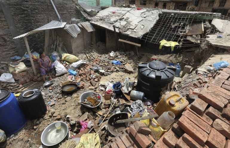 NEP14 KATMANDÚ (NEPAL) 20/05/2015.- Una mujer vigila sus pertenencias en la zona de Bungamati, en Katmandú (Nepal) hoy, miércoles 20 de mayo de 2015. Los terremotos que sacudieron Nepal los pasados 25 de abril y 12 de mayo causaron unos 8.600 muertos, más de 16.000 heridos y casi medio millón de viviendas quedaron completamente destruidas. EFE/Harish Tyagi