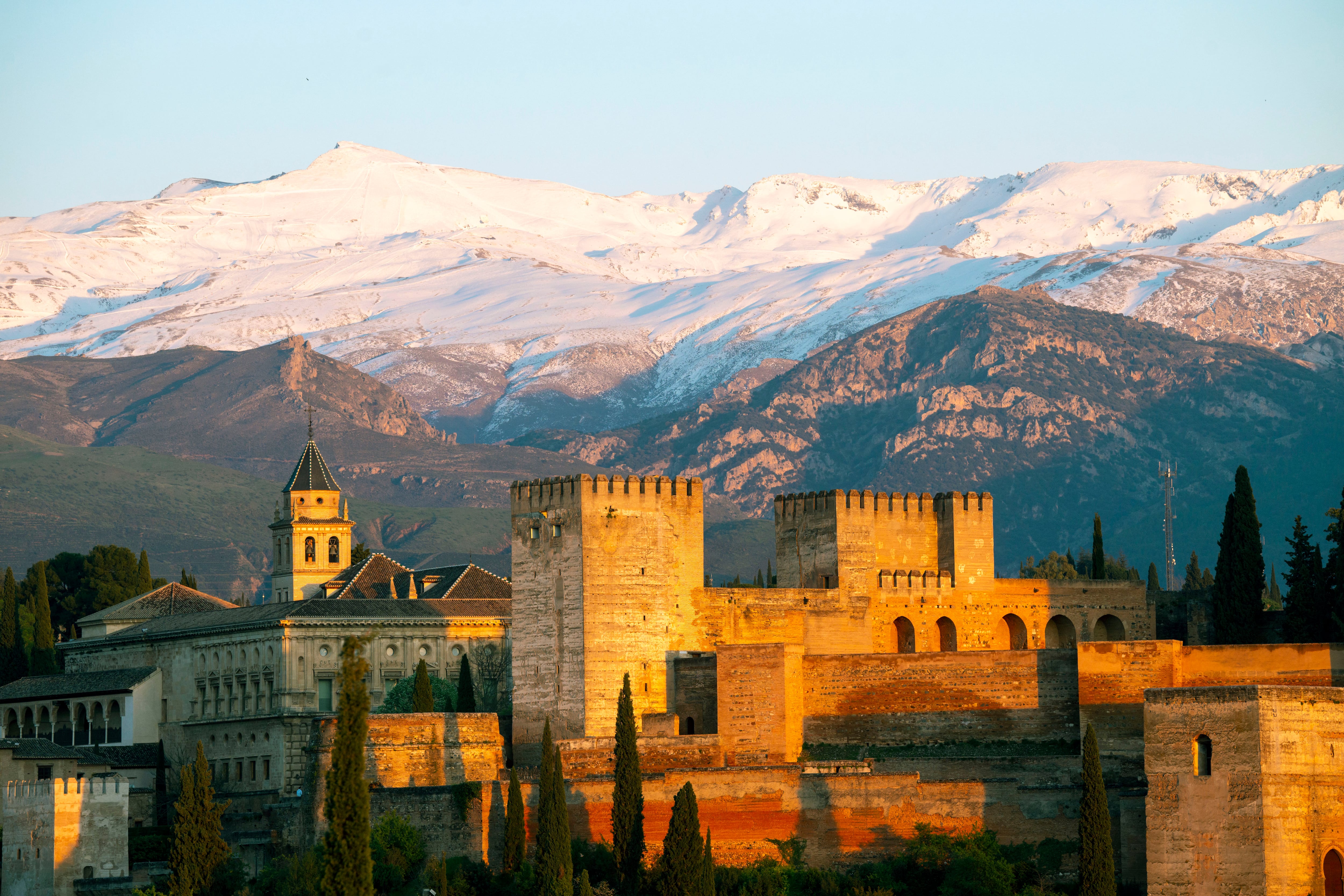 La Alhambra de Granada, con Sierra Nevada al fondo, en una imagen de la puesta de sol del 4 de abril de 2024 que puede contemplarse desde la Iglesia de Santa María de la Aurora y San Miguel en pleno barrio morisco del Albaicín