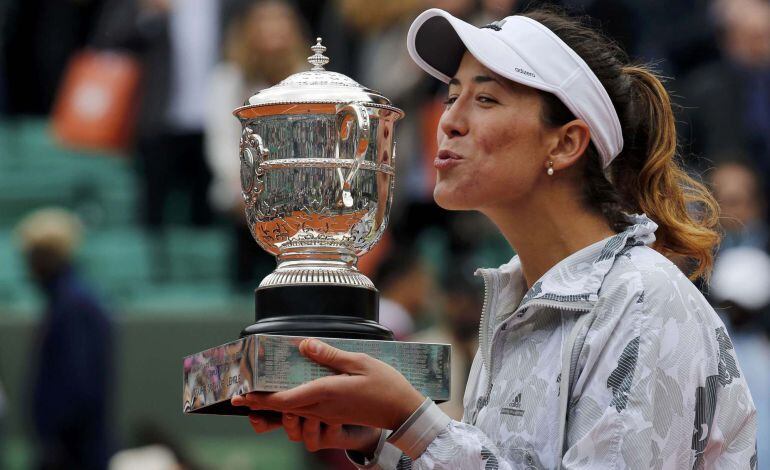 Garbiñe Muguruza sonríe mientras mira de reojo el trofeo de campeona