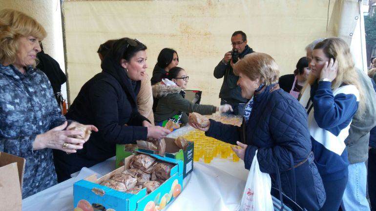 Maite Fernández y la representante del PP Graci Casado reparten los bocadillos de chorizo a los ciudadanos de Puertollano