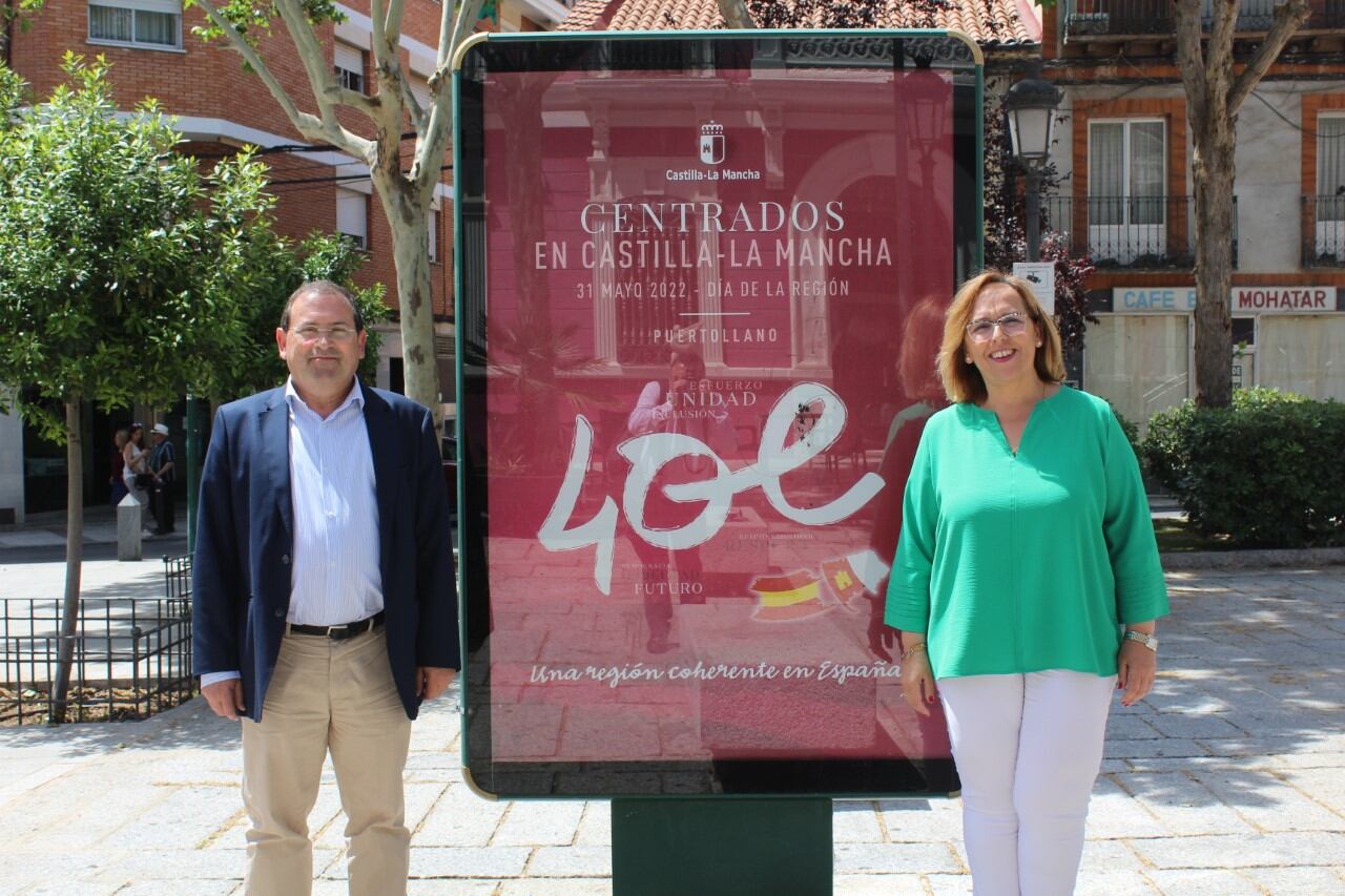 Carmen Olmedo y Adolfo Muñiz frente a un cartel promocional de la celebración del Día de Castilla-La Mancha en Puertollano