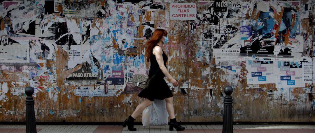 Una mujer con mascarilla camina este jueves por una céntrica calle de A Coruña