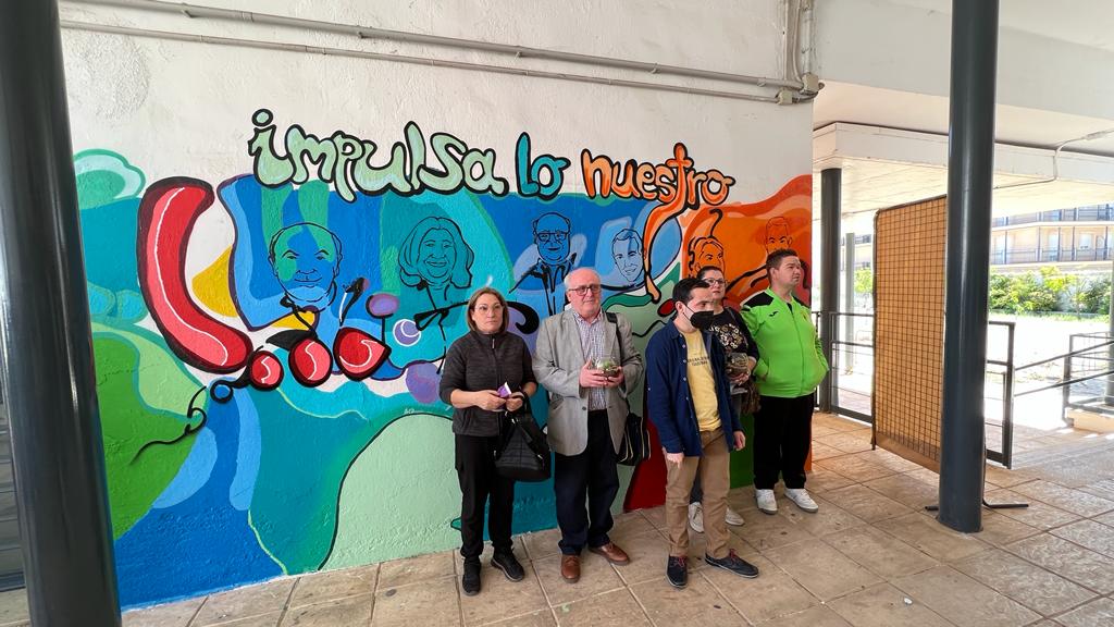 Momento de presentación del mural con caricaturas de los colaboradores en el programa