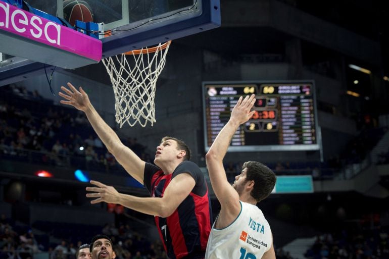 El pivot alemán del Kirolbet Baskonia Johannes Voigtman lanza a canasta ante el alero del Real Madrid Santi Yusta.