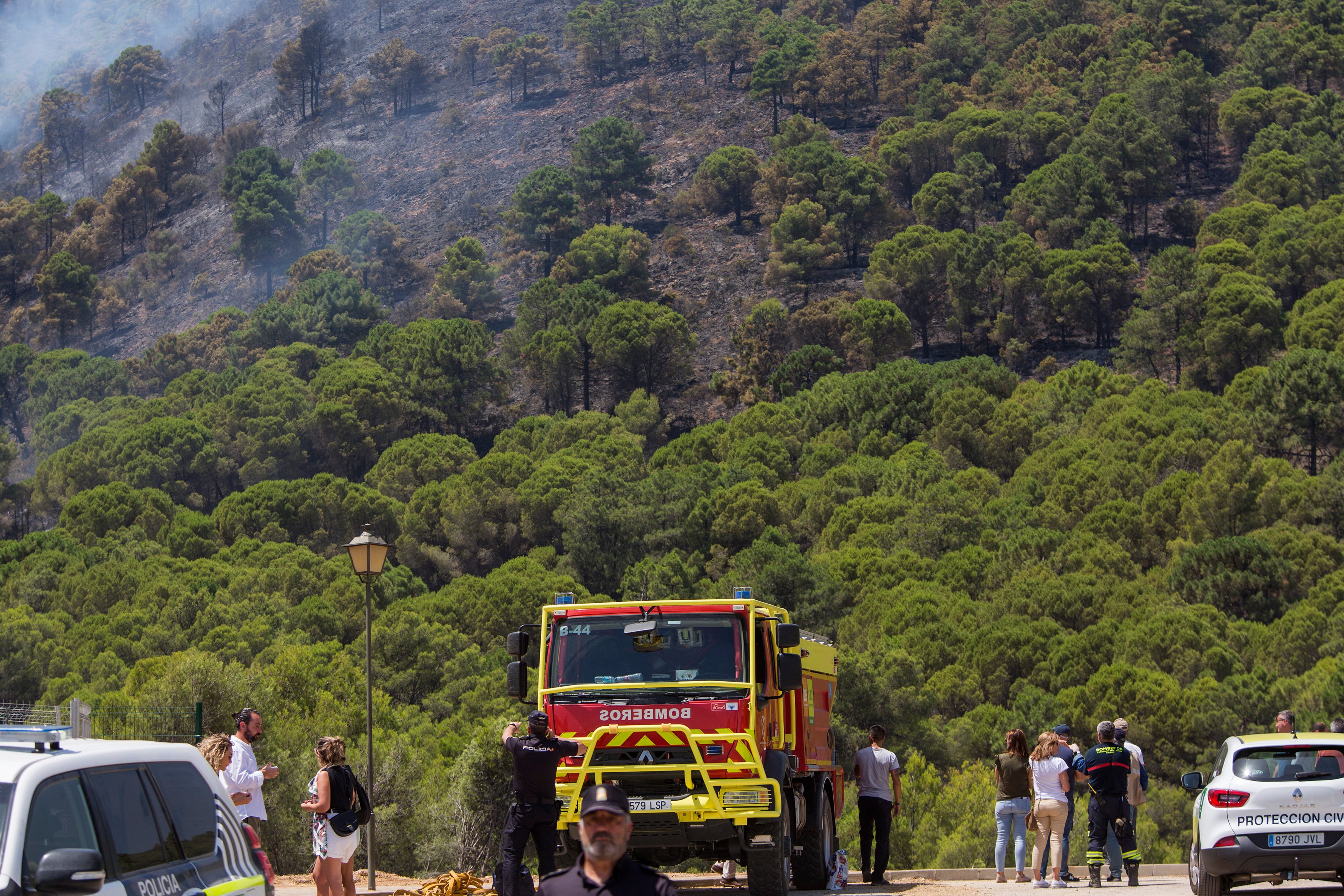 ALHAURÍN DE LA TORRE (MÁLAGA), 17/07/2022.- Varios curiosos se congregan junto a una zona quemada del incendio de la Sierra de Mijas próxima a la urbanización Pinos de Alhaurín, este domingo en Alhaurín de la Torre. EFE/Álvaro Cabrera
