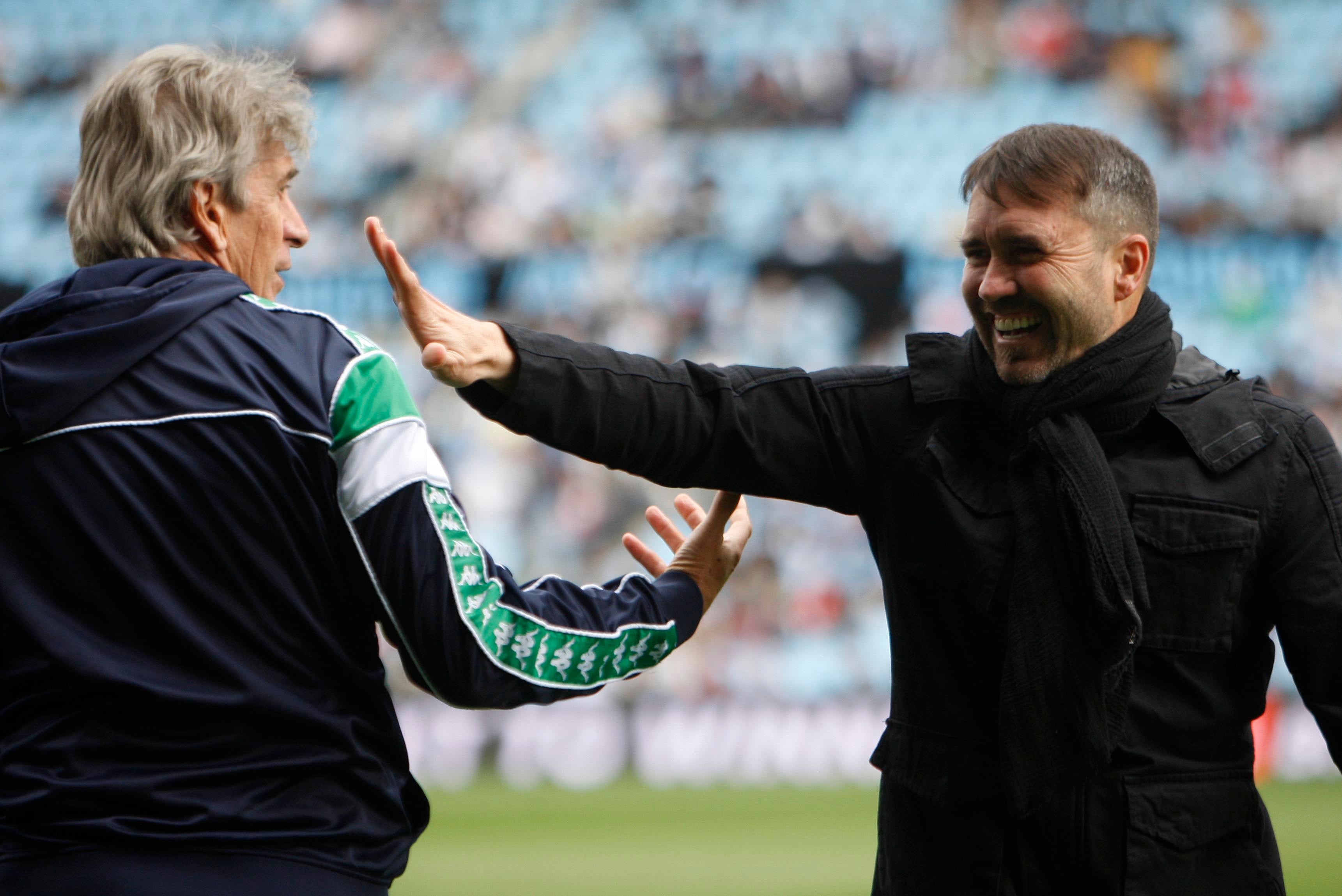 GRAF3091. VIGO, 20/03/2022.- El entrenador del Betis Manuel Pellegrini y el del Celta Coudet se saludan al inicio del partido de Liga entre el Celta de Vigo y el Real Betis, disputado este domingo en el Estadio Balaídos de Vigo. EFE / Salvador Sas