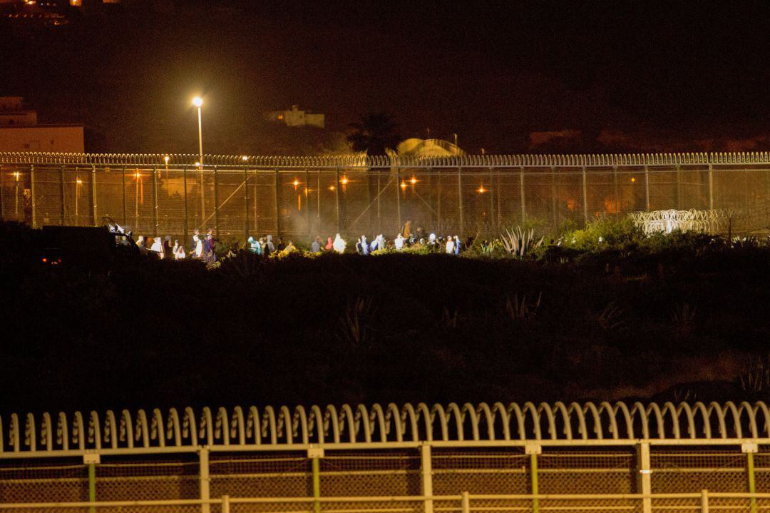 Varios marroquíes intentan llegar a suelo español desde la frontera que separa Melilla y Marruecos, en una imagen de archivo.