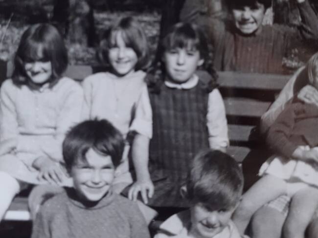 De niña, con sus amigos del barrio de la Virgen y la pierna escayolada