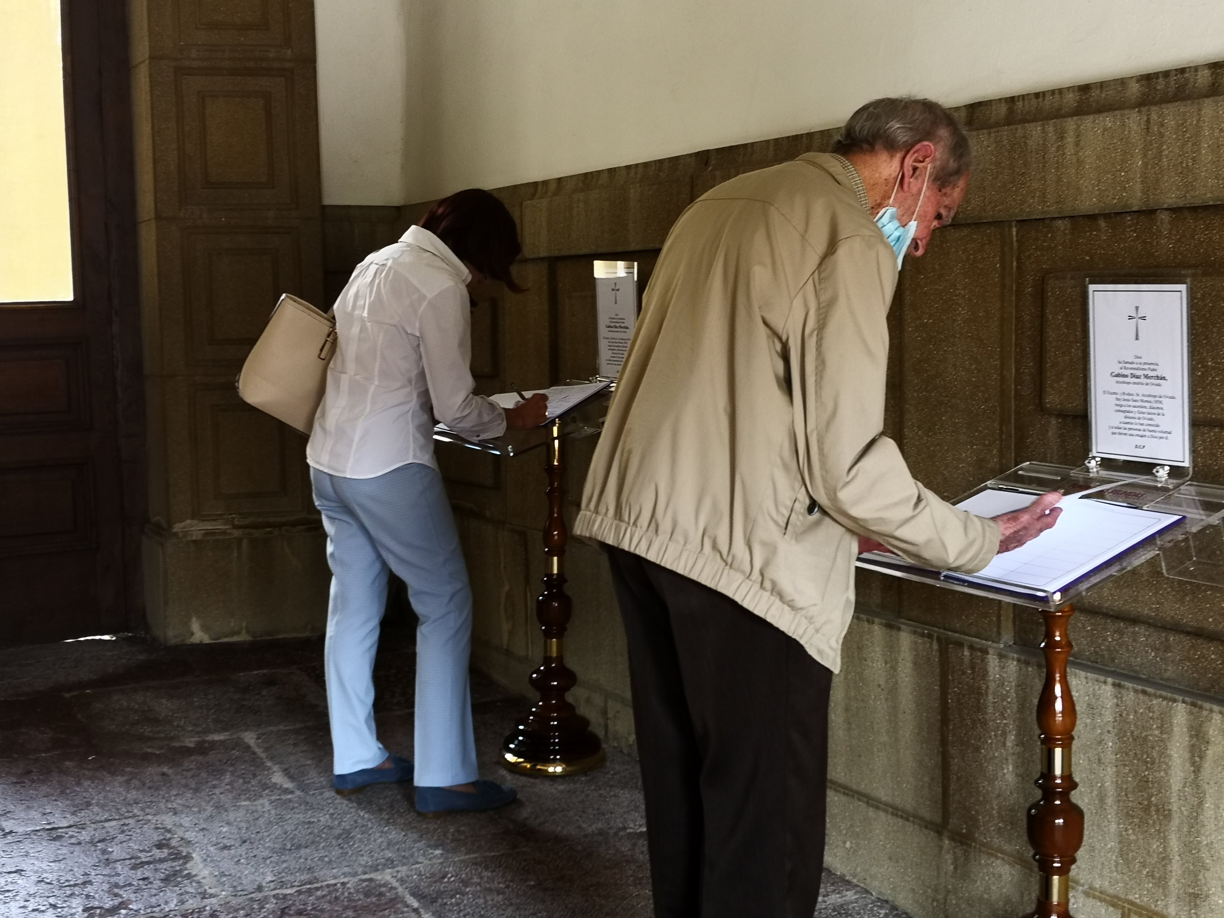 Ciudadanos escriben en los libros de condolencias instalados en el Palacio del Arzobispado de Oviedo por el fallecimiento de D. Gabino Díaz Merchán