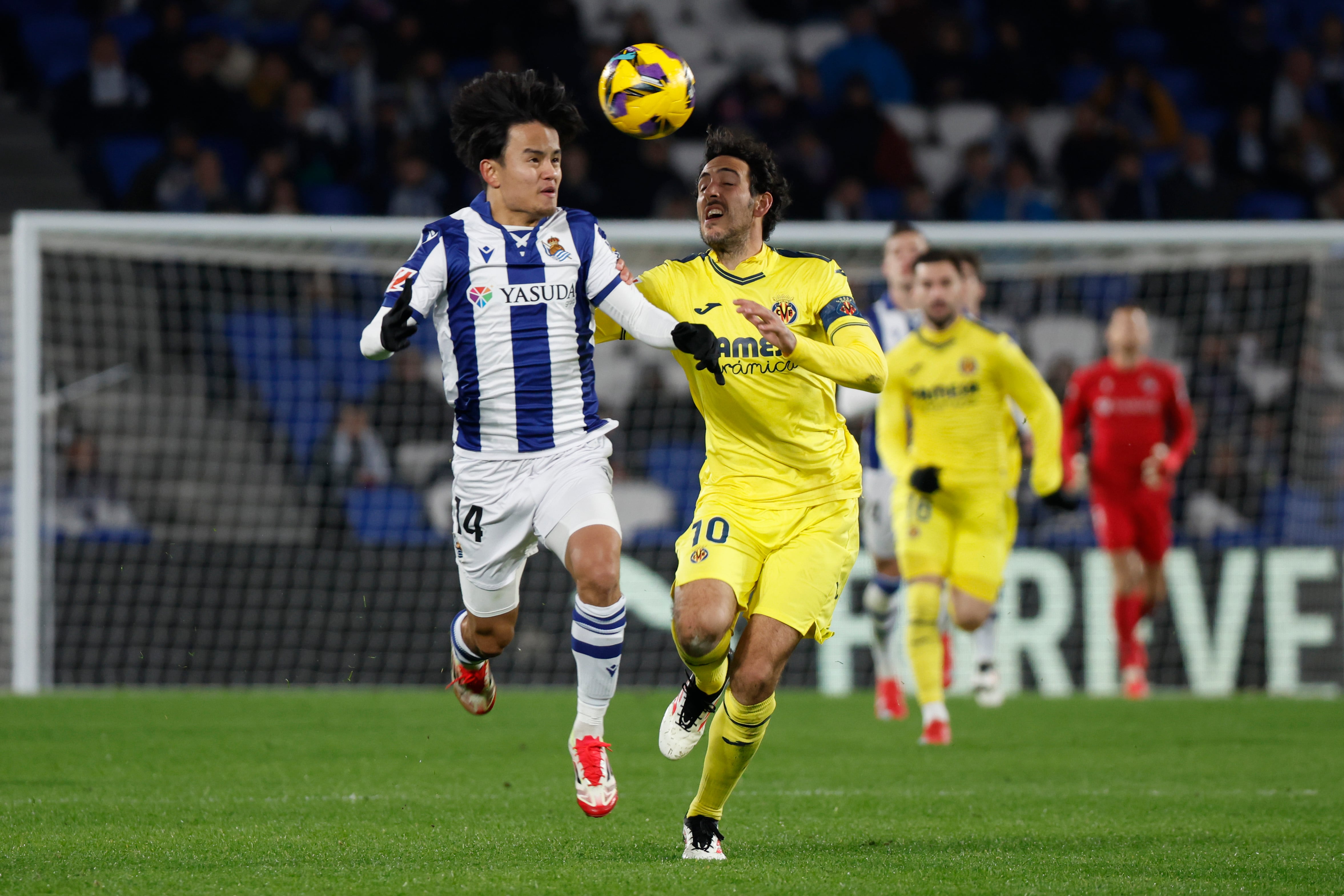 SAN SEBASTIÁN, 13/01/2025.- El centrocampista japonés de la Real Sociedad Takefusa Kubo (i) lucha con Dani Parejo, del Villarreal, durante el encuentro correspondiente a la jornada 19 de LaLiga EA Sports que Real Sociedad y Villarreal disputan hoy lunes en el estadio de Anoeta, en San Sebastián. EFE / Juan Herrero.
