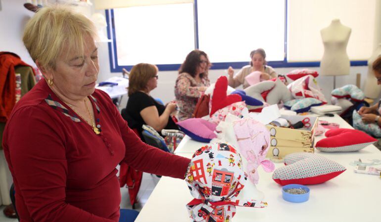 Alumnas del taller de Artesanía Textil de la Universidad Popular hacen gorros y cojínes adaptados para enfermos de cáncer. 