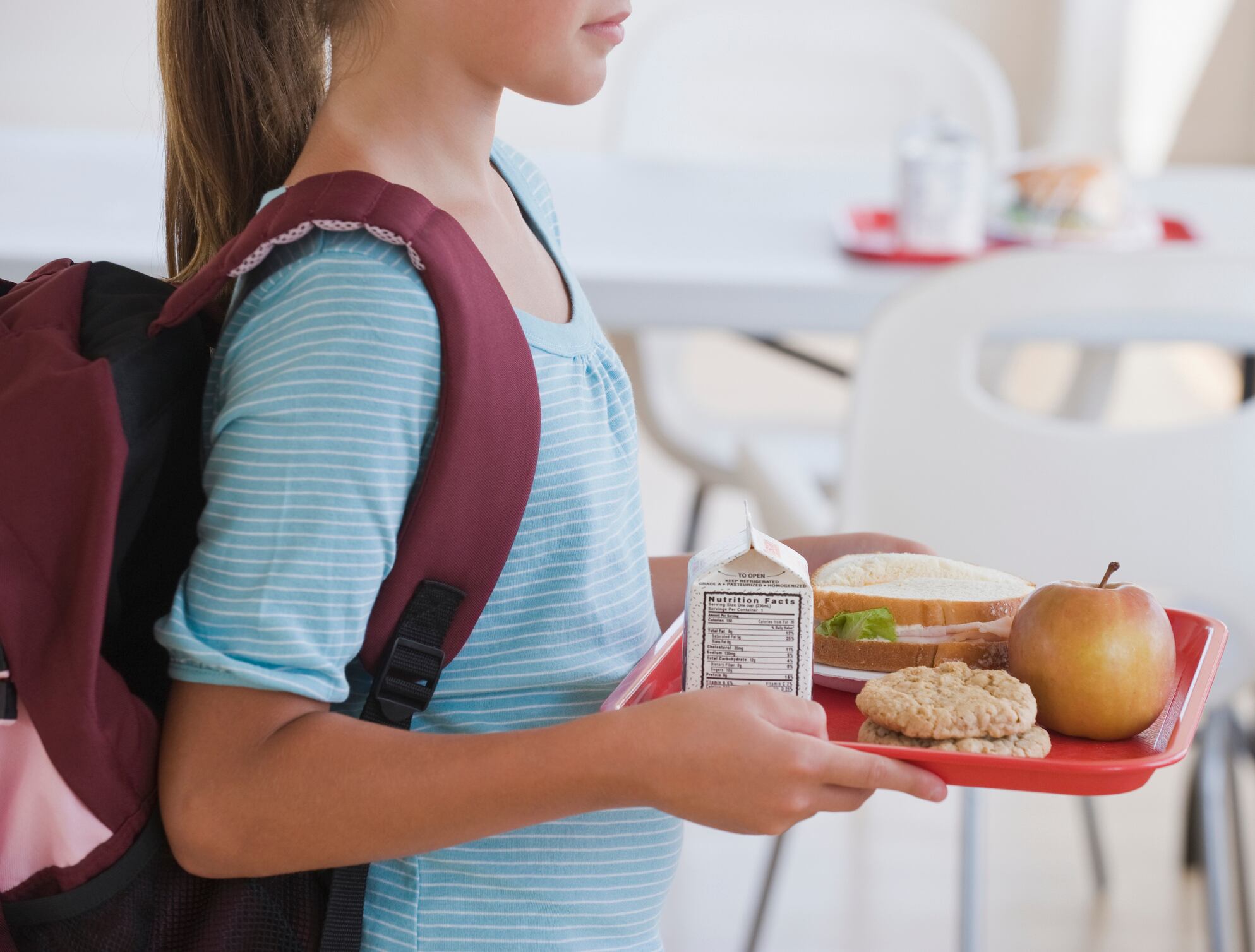 Niña con una bandeja de comida en el colegio / Archivo