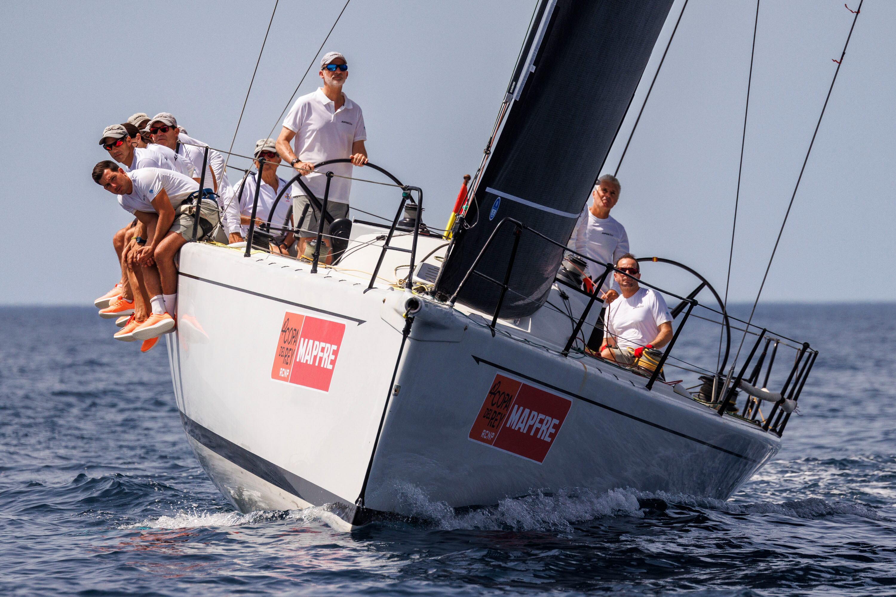 PALMA DE MALLORCA, 28/07/2024.- El rey Felipe VI (c-i) se embarca este domingo en el Aifos para preparar la 42 edición de la Copa del Rey Mapfre de vela que comienza este martes en Palma de Mallorca, en la que el barco de la Armada va a competir en la categoría ORC 0 junto a otras seis embarcaciones. EFE/ 42 Copa de Rey MAPFRE/ Nico Martínez SOLO USO EDITORIAL/ SOLO USO PERMITIDO PARA ILUSTRAR LA NOTICIA QUE ACOMPAÑA/ (CRÉDITO OBLIGATORIO)
