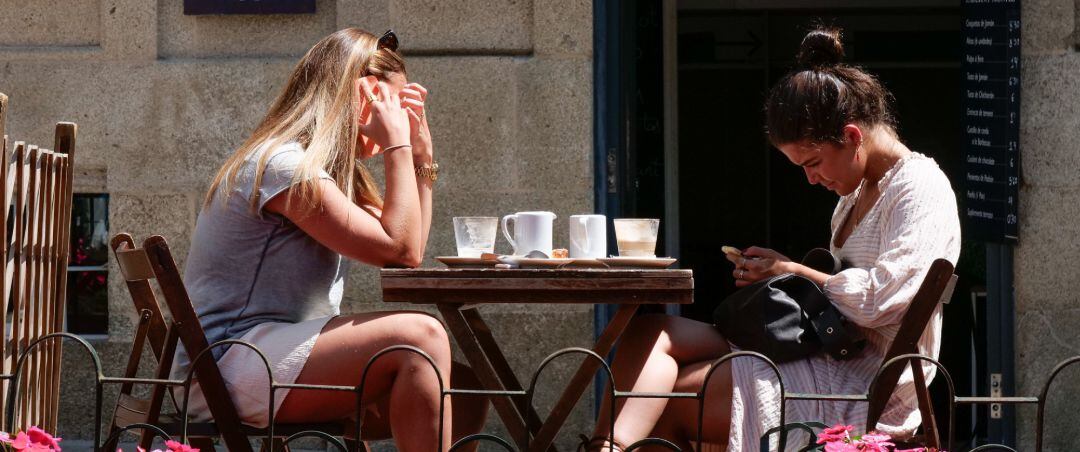 Dos mujeres en la terraza de un restaurante de la Rua da Raiña, el día en que el TSXG declara nula la petición de certificado Covid para entrar en hostelería, a 12 de agosto de 2021