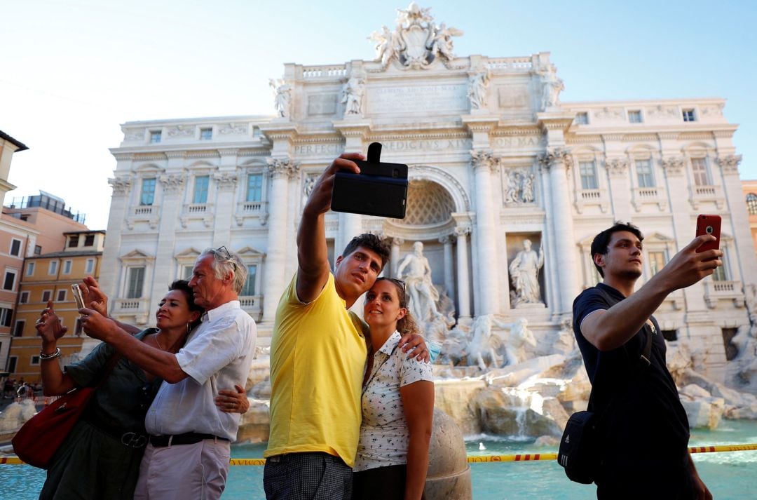 Varios turistas se hacen selfis 