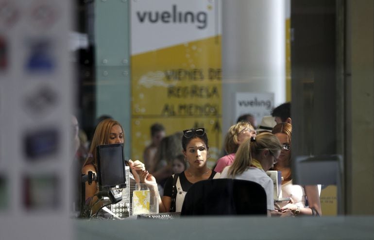 Personal de facturación de Vueling atiende a los viajeros en el Aeropuerto de El Prat