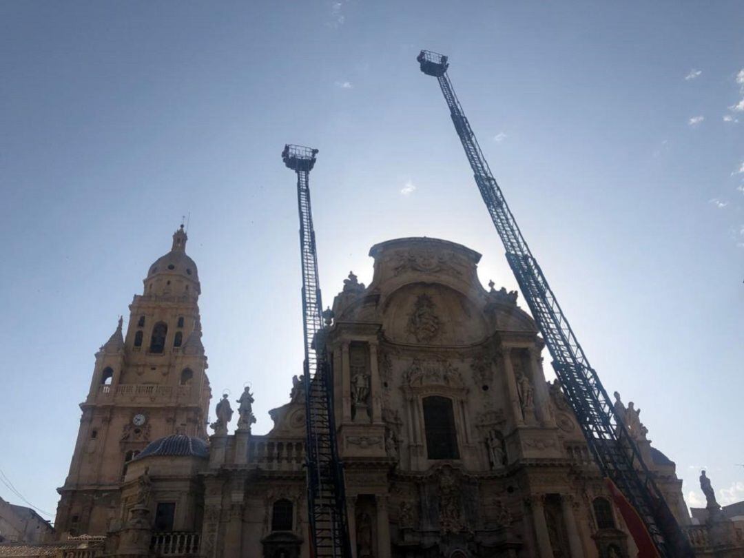 Las escaleras de los camiones de bomberos se alzan sobre la fachada de la Catedral de Murcia