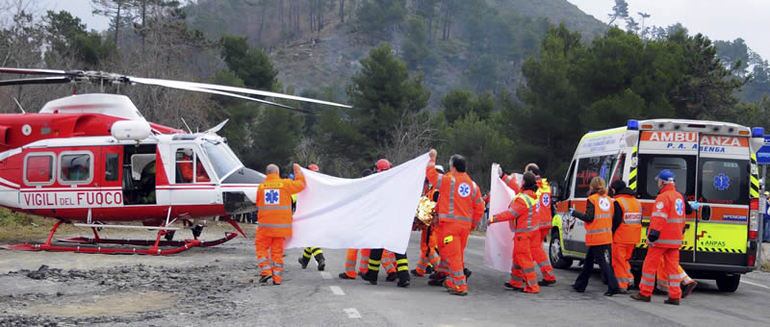 Personal médico protege con una sábana al piloto polaco Robert Kubica mientras le trasladan en camilla hasta un helicóptero tras sufrir un grave accidente en el rally &quot;Ronde di Andora&quot;