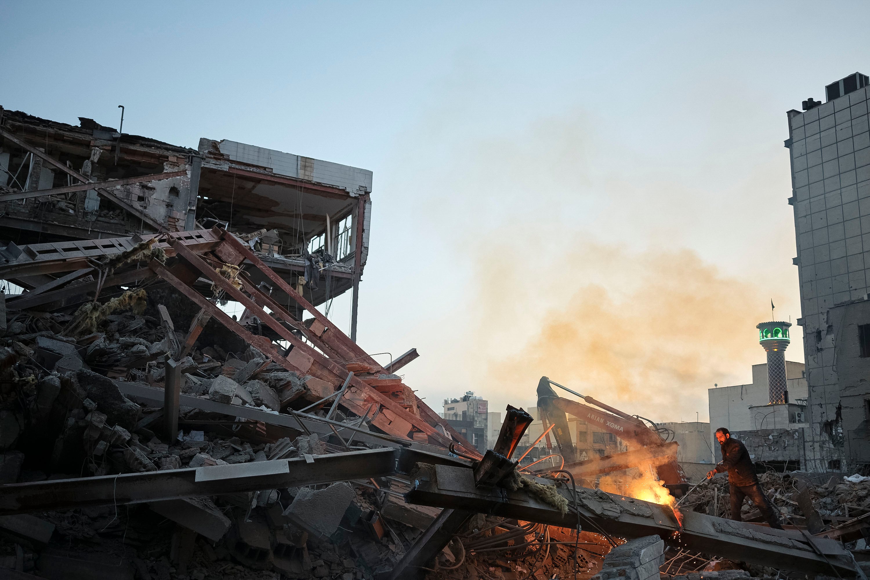 Un soldador trabaja en las ruinas de un edificio destruido en la noche del 26 de marzo en un ataque israelí-estadounidense en plaza Nilufar en el este de Teherán (Irán).
