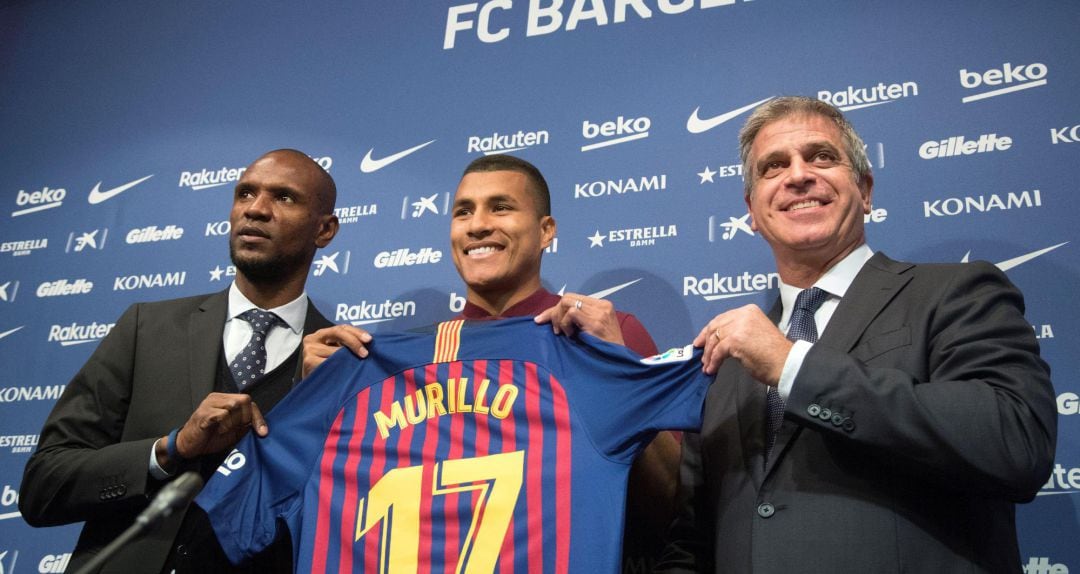 El defensa colombiano Jeison Murillo, junto al vicepresidente deportivo del FC Barcelona, Jordi Mestre (d), y el director deportivo del club, Eric Abidal (i).