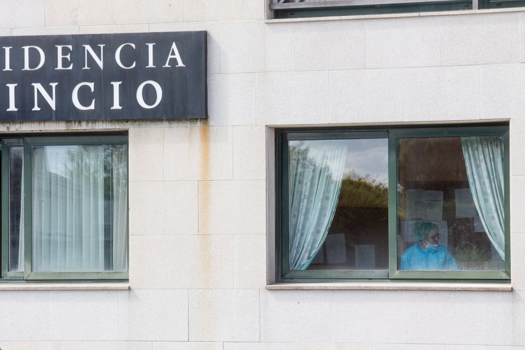 Una sanitaria en una ventana de la residencia de ancianos de O Incio, en Lugo (España).