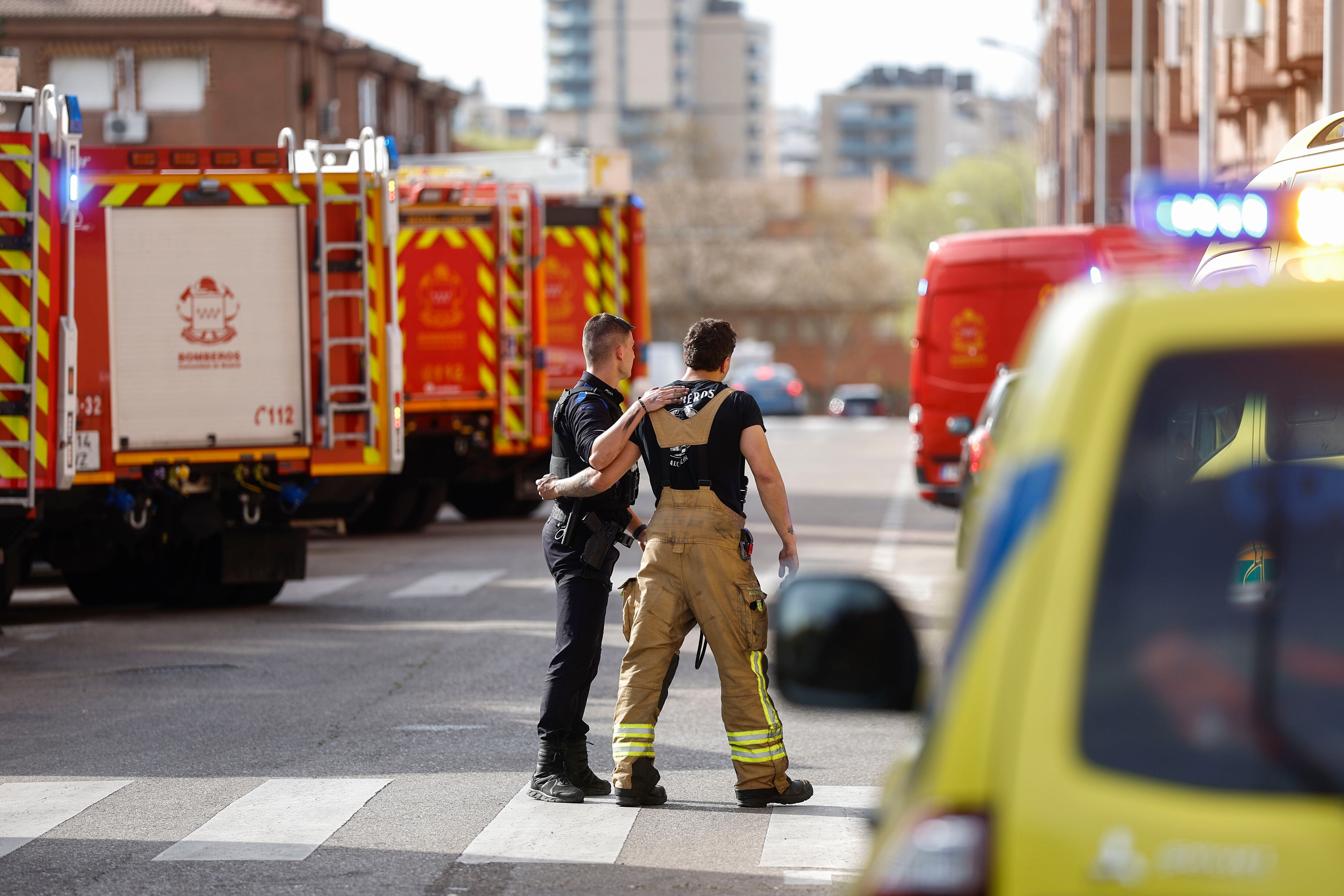 ALCORCÓN (CA MADRID), 02/04/2025.- Agentes de la policía acompañan a un bombero en las inmediaciones del garaje de Alcorcón (Madrid) donde este miércoles se ha originado un incendio causando la muerte a dos bomberos, y otros cinco han resultado heridos por inhalación de humo. EFE/ Rodrigo Jimenez